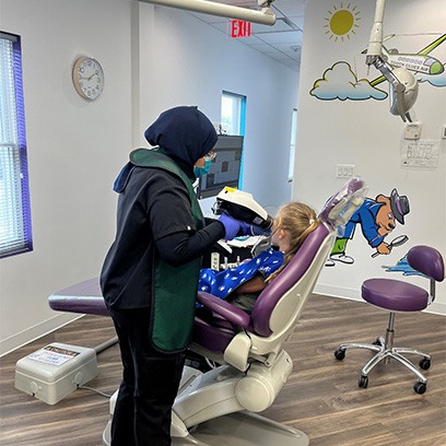 A dental assistant taking X-rays of a child’s mouth