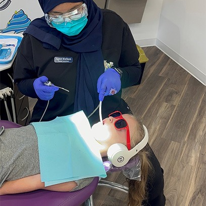 A dental hygienist cleaning a patient’s teeth