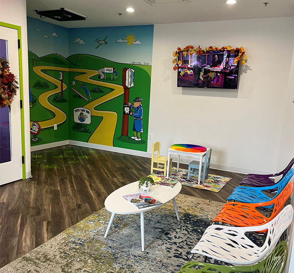 Tooth Clues’ waiting area with colorful chairs and a wall mural