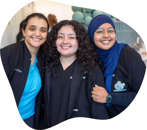 Three smiling pediatric dental team members